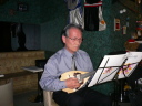 A man playing mandolin ̂Q